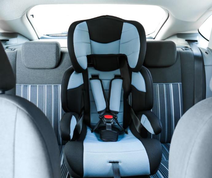 Child buckled safely into a car seat in the back of a modern vehicle